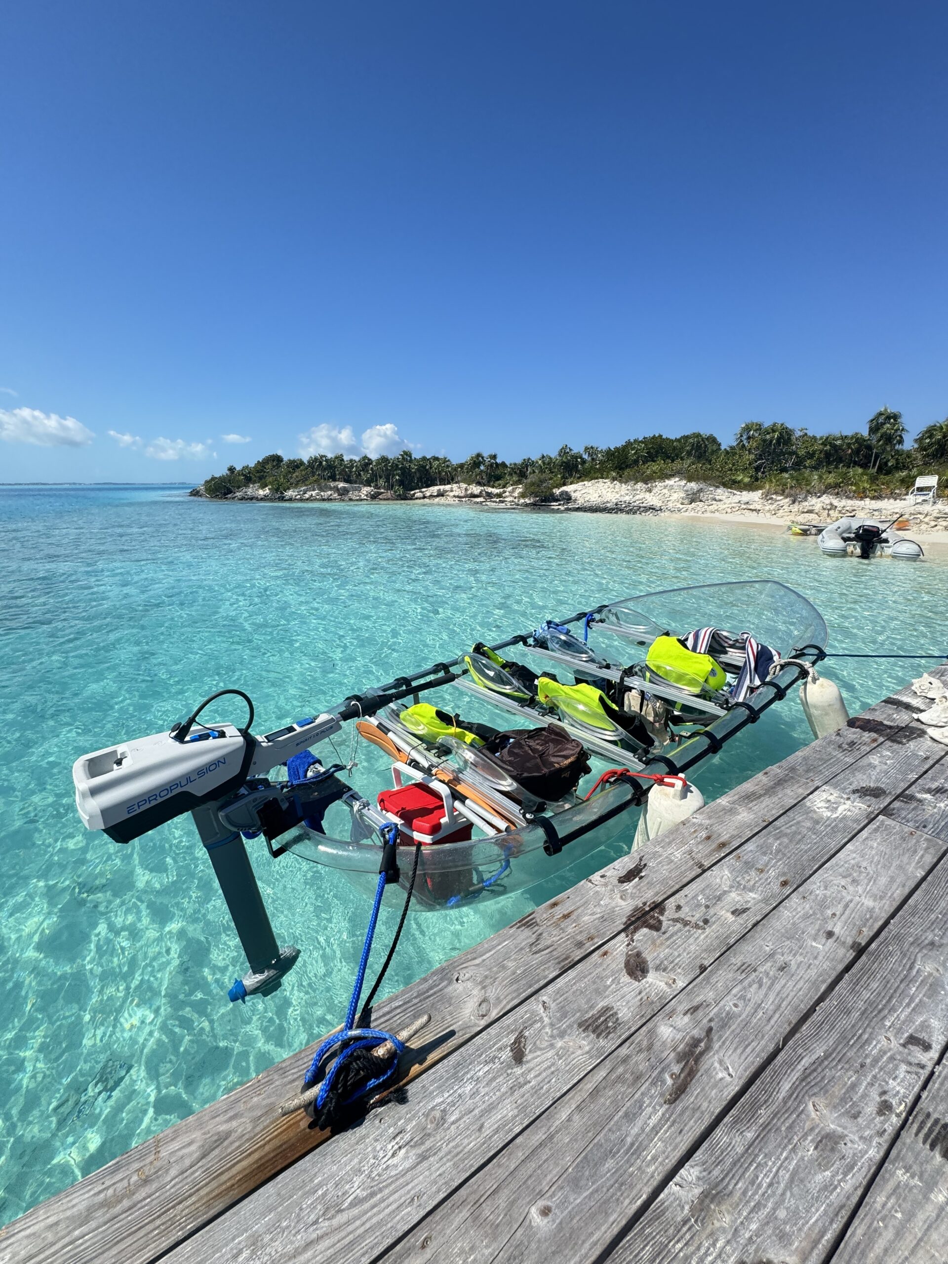 Clear Wave motorized clear kayak docked beside turquoise water